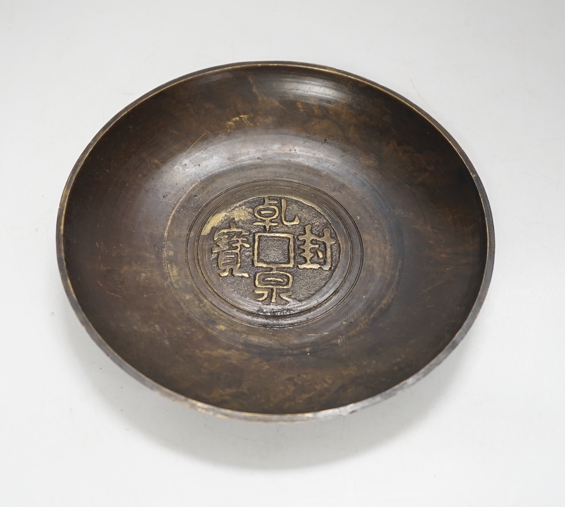 A Chinese bronze dish, 'coin' design to the centre, 18cm diameter